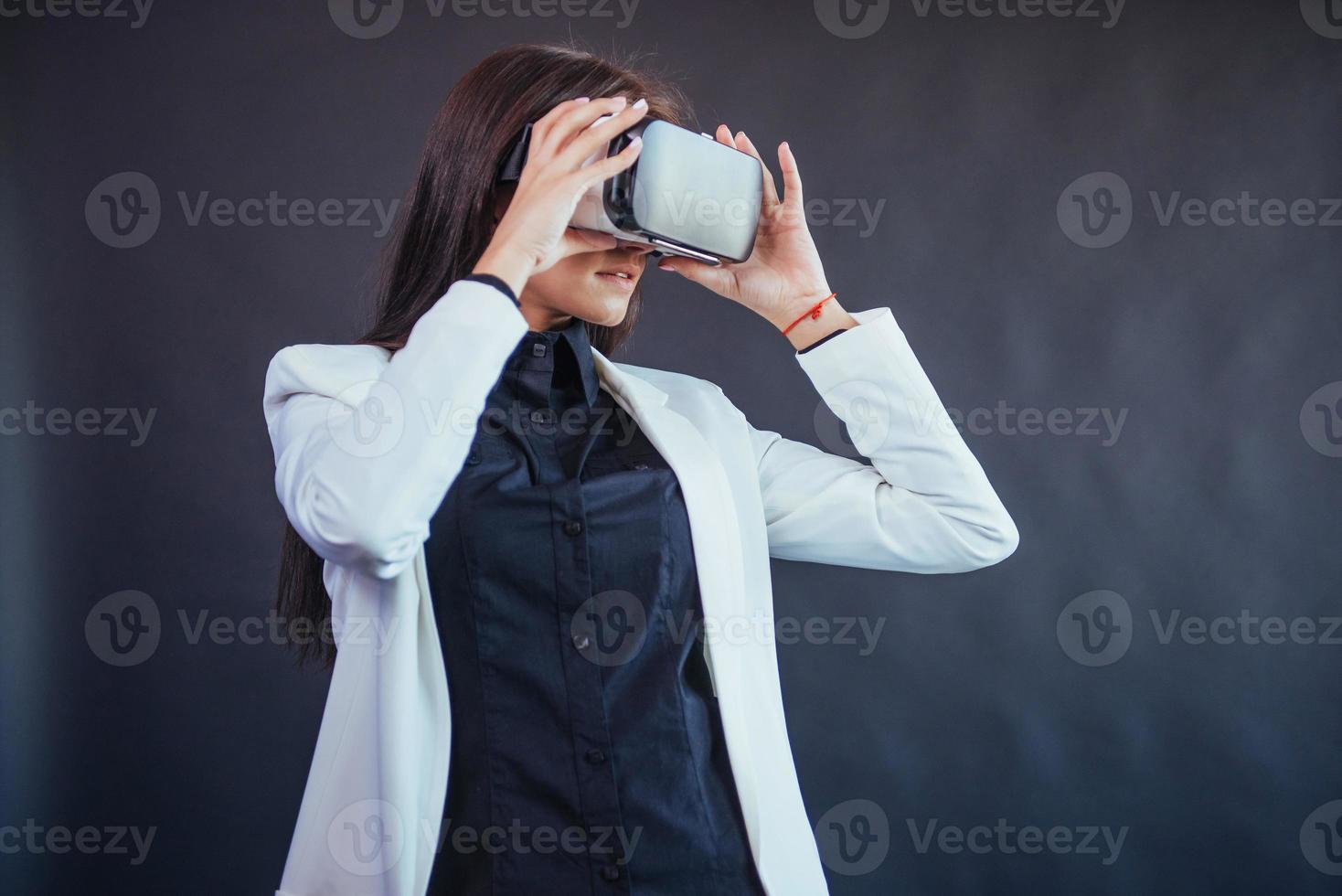 glückliche frau auf schwarzem hintergrund im studio bekommt die erfahrung mit dem virtual-reality-headset der vr-brille. foto