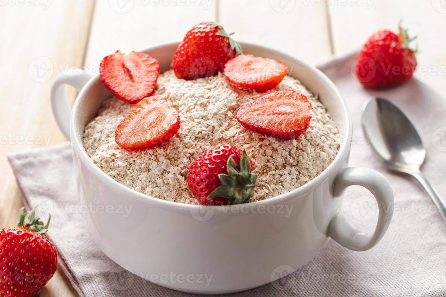 Hafermüsli und frische Erdbeeren auf Holzhintergrund. foto