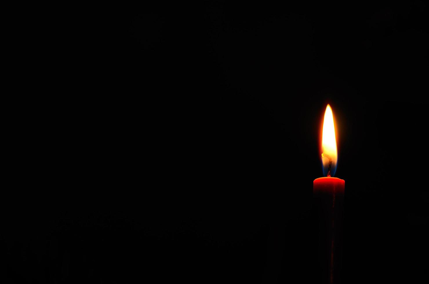 rot leuchtende Kerze im Dunkeln foto
