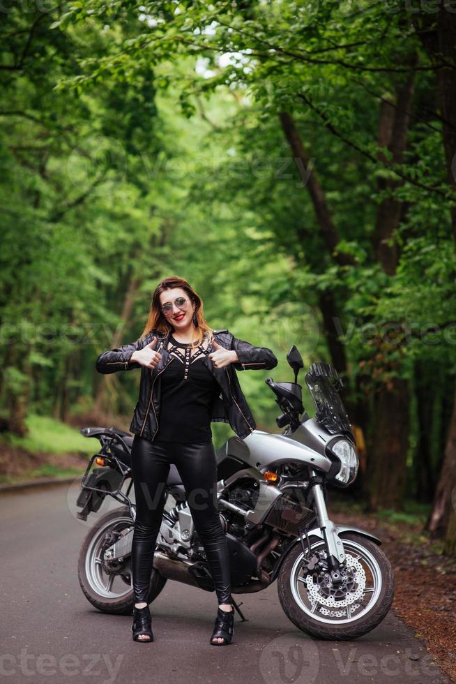 Ein attraktives sexy Mädchen auf einem Sportmotorrad, das draußen posiert foto