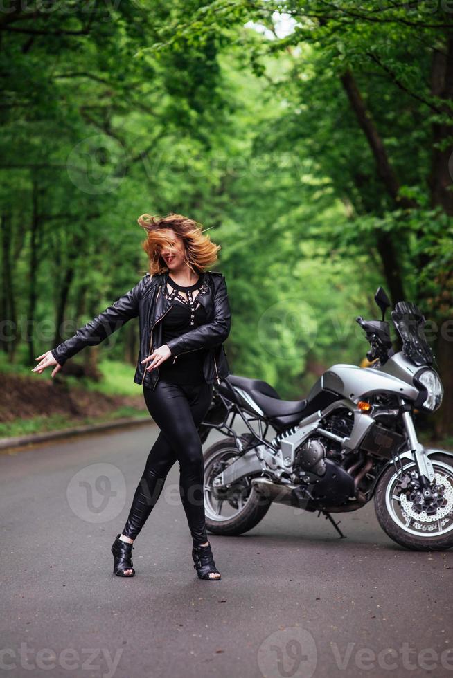 Ein attraktives sexy Mädchen auf einem Sportmotorrad, das draußen posiert foto