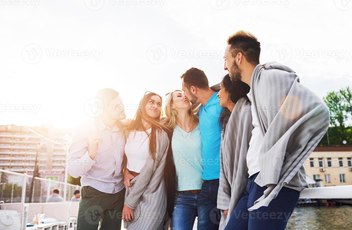 Porträt eines jungen und glücklichen Menschen in Ruhe auf dem Pier. Freunde, die ein Spiel auf dem See genießen. positive Gefühle. foto