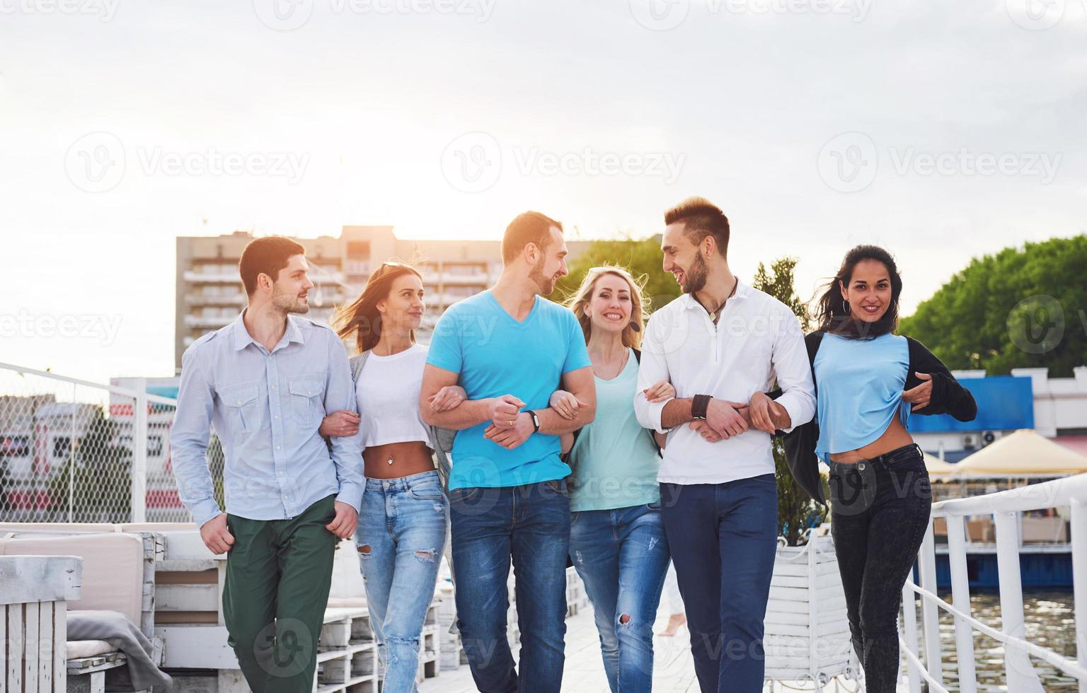 Porträt eines jungen und glücklichen Menschen in Ruhe auf dem Pier. Freunde, die ein Spiel auf dem See genießen. positive Gefühle. foto