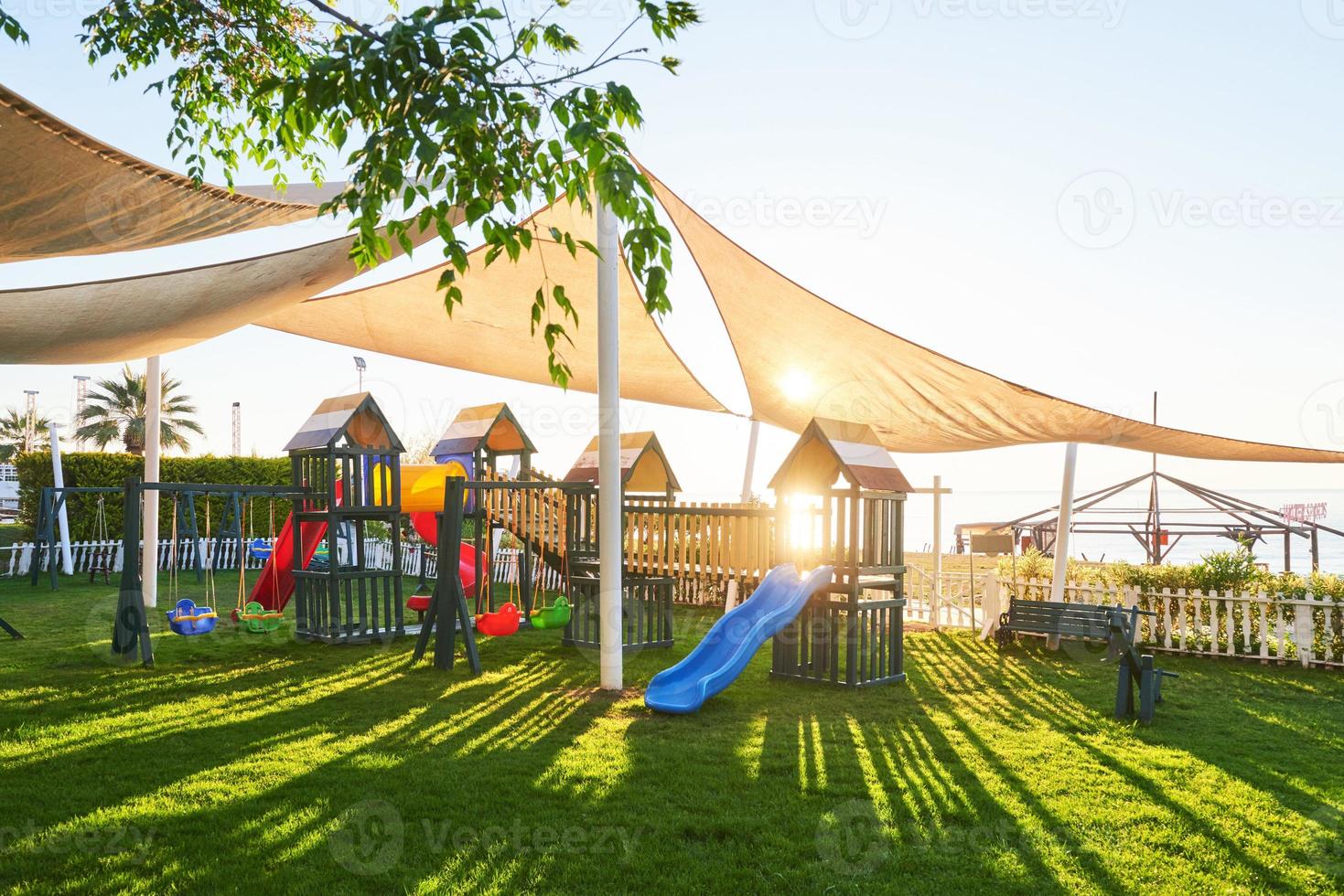 bunter spielplatz im hof im park bei sonnenuntergang. foto