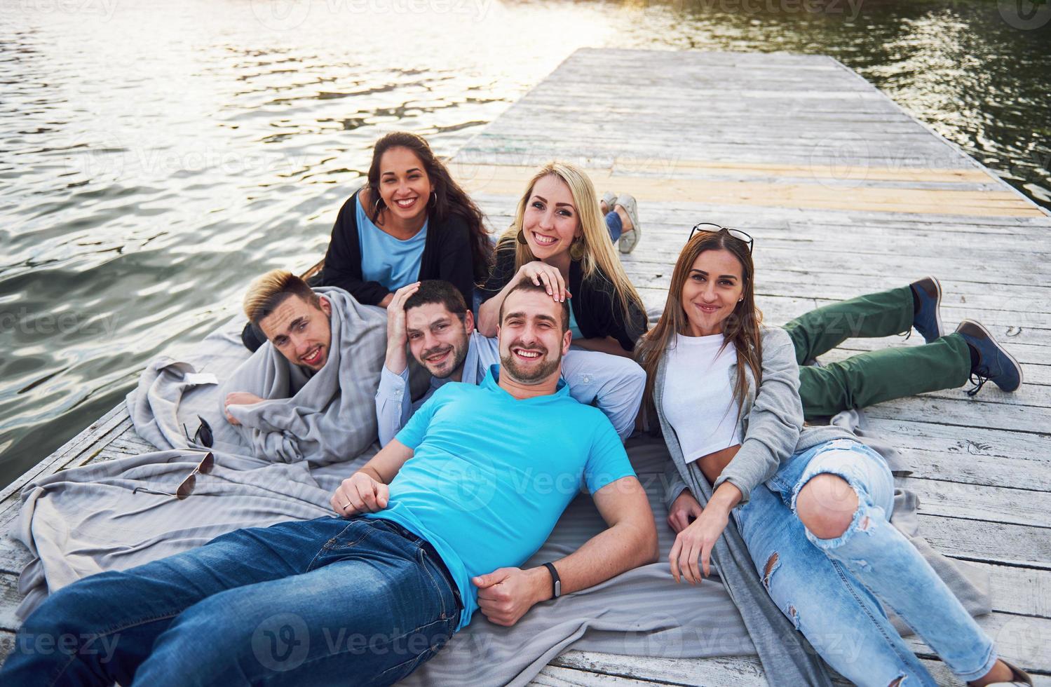 gruppe schöner junger leute auf dem pier, freundzufriedenheit schafft emotionales leben foto