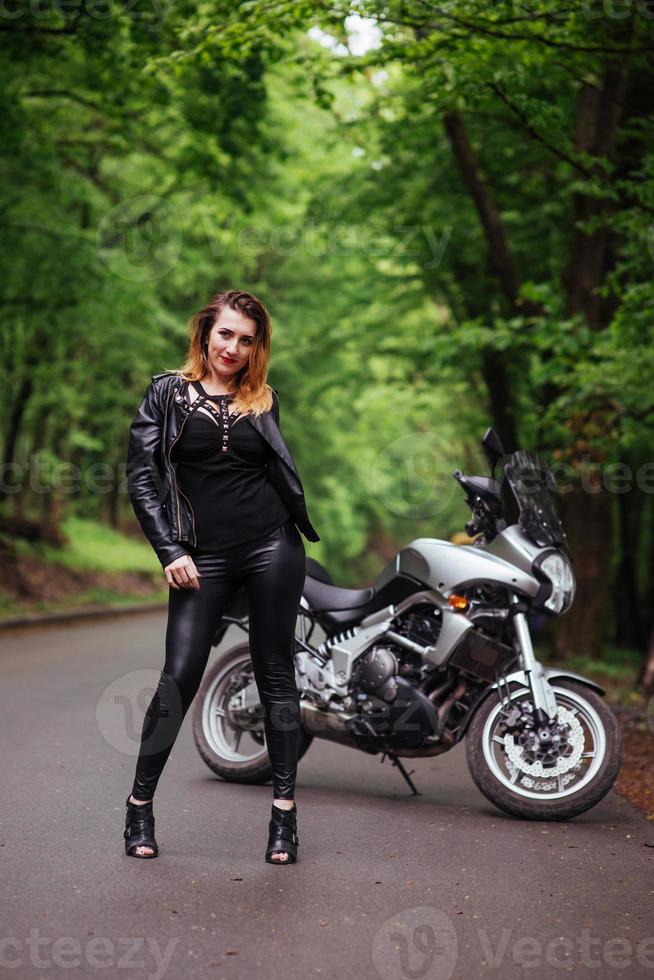 Ein attraktives sexy Mädchen auf einem Sportmotorrad, das draußen posiert foto