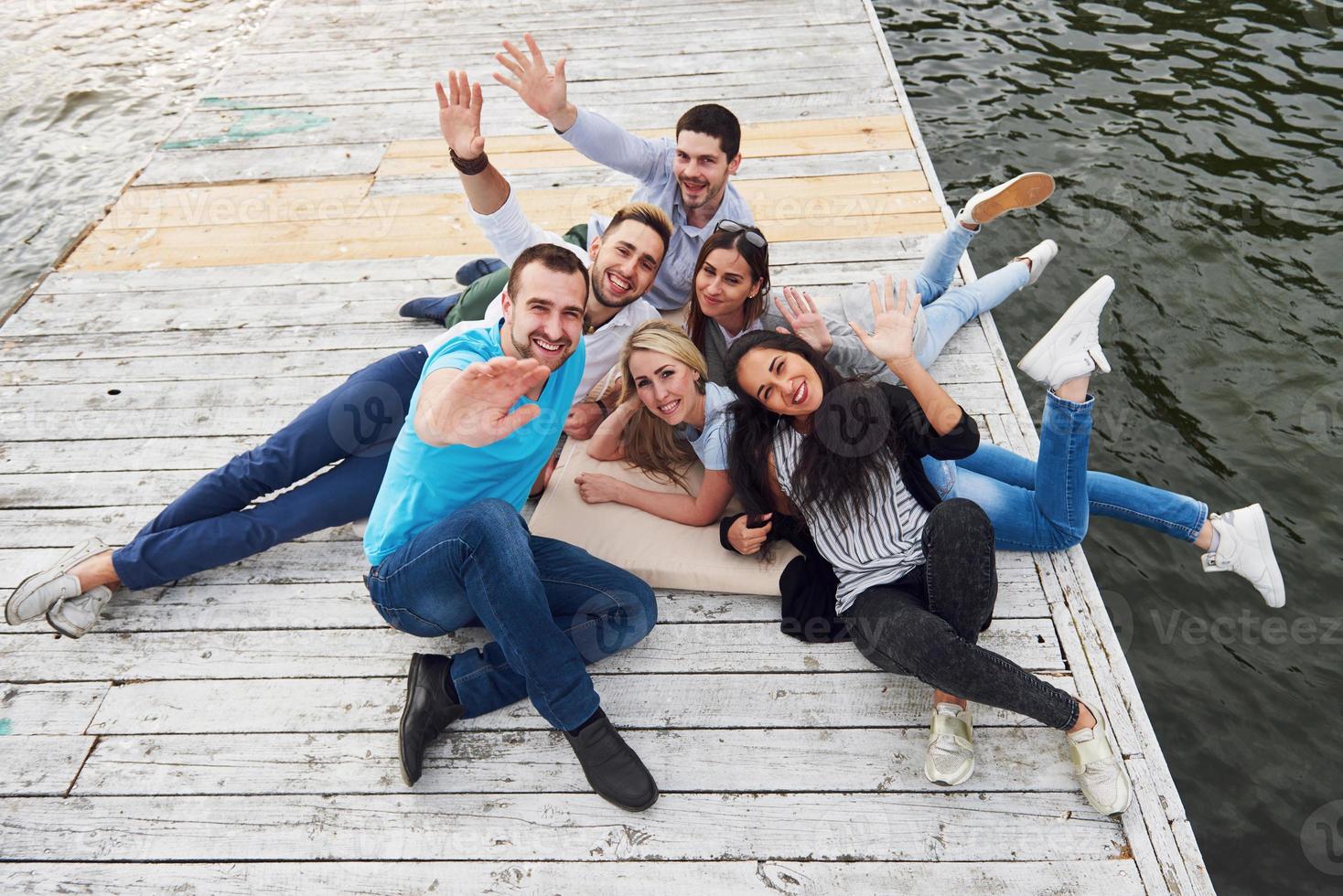 gruppe schöner junger leute auf dem pier, freundzufriedenheit schafft emotionales leben foto