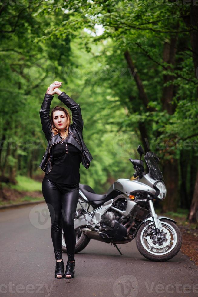 Ein attraktives sexy Mädchen auf einem Sportmotorrad, das draußen posiert foto