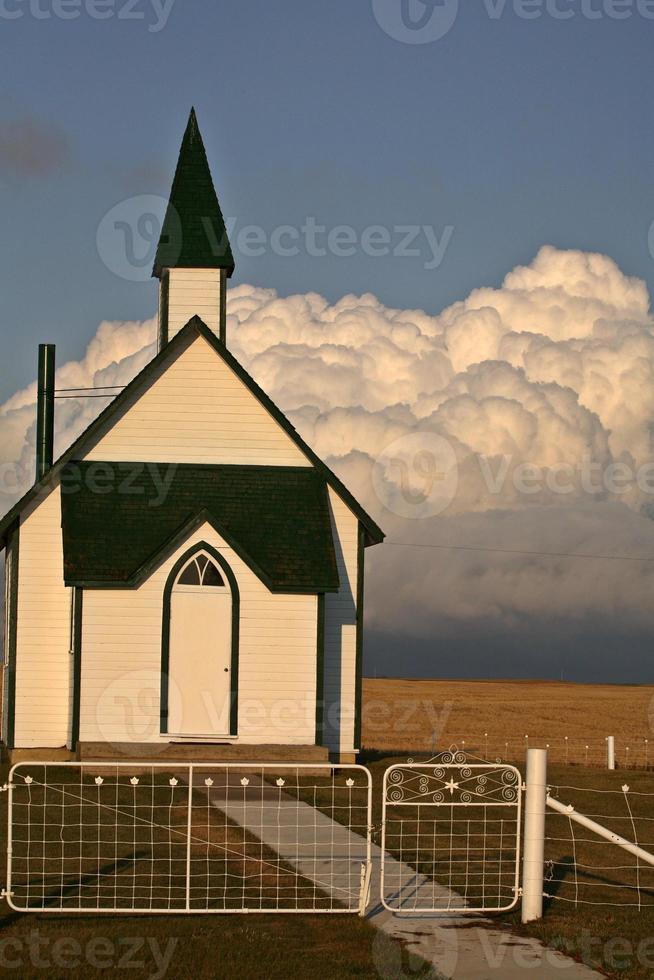 Gewitterwolken bilden sich hinter einer Landkirche foto