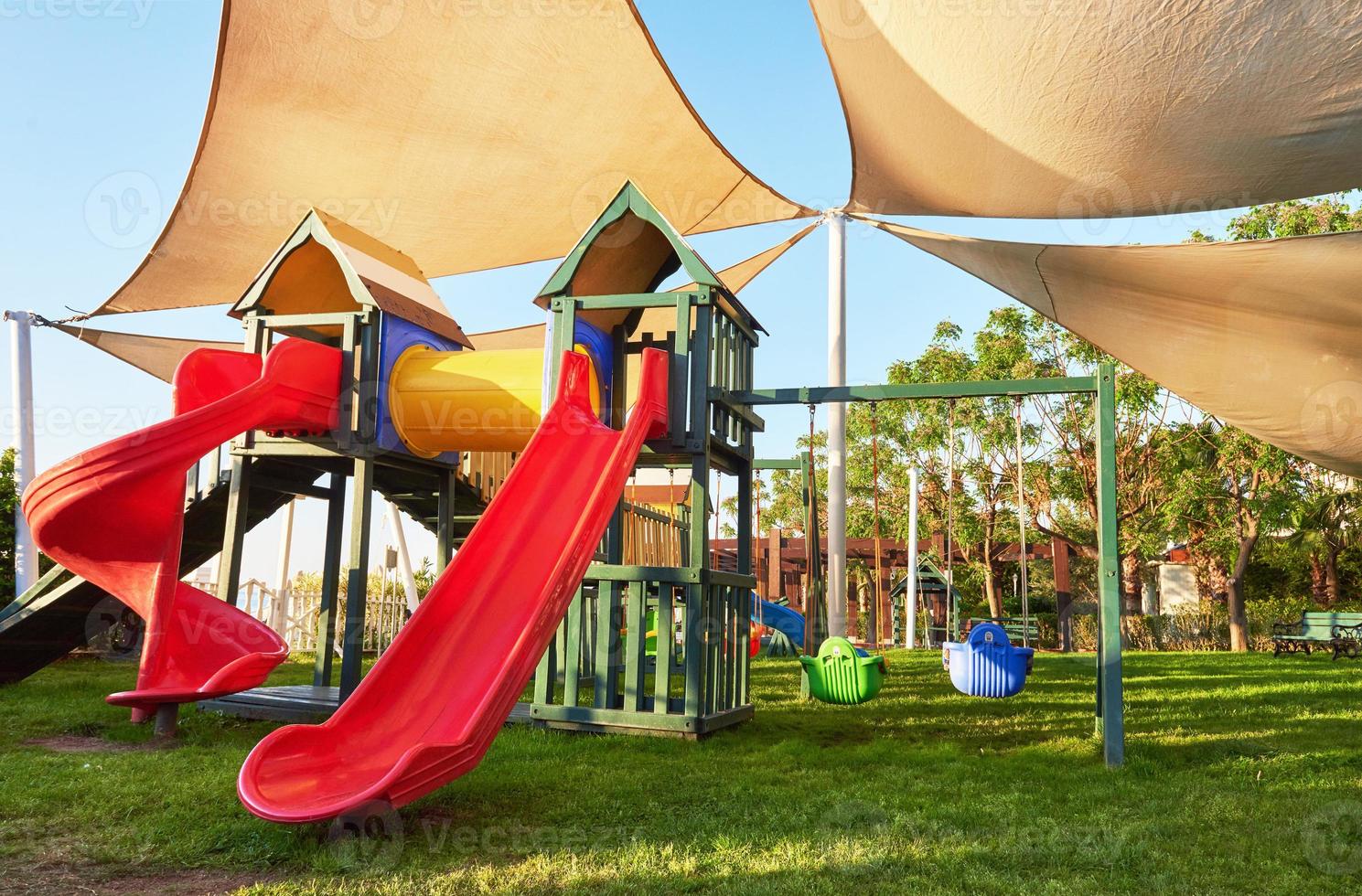 bunter spielplatz im hof im park bei sonnenuntergang. foto