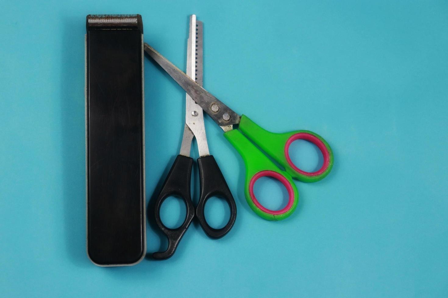 zwei Scheren und ein Haarschneider auf blauem Hintergrund foto