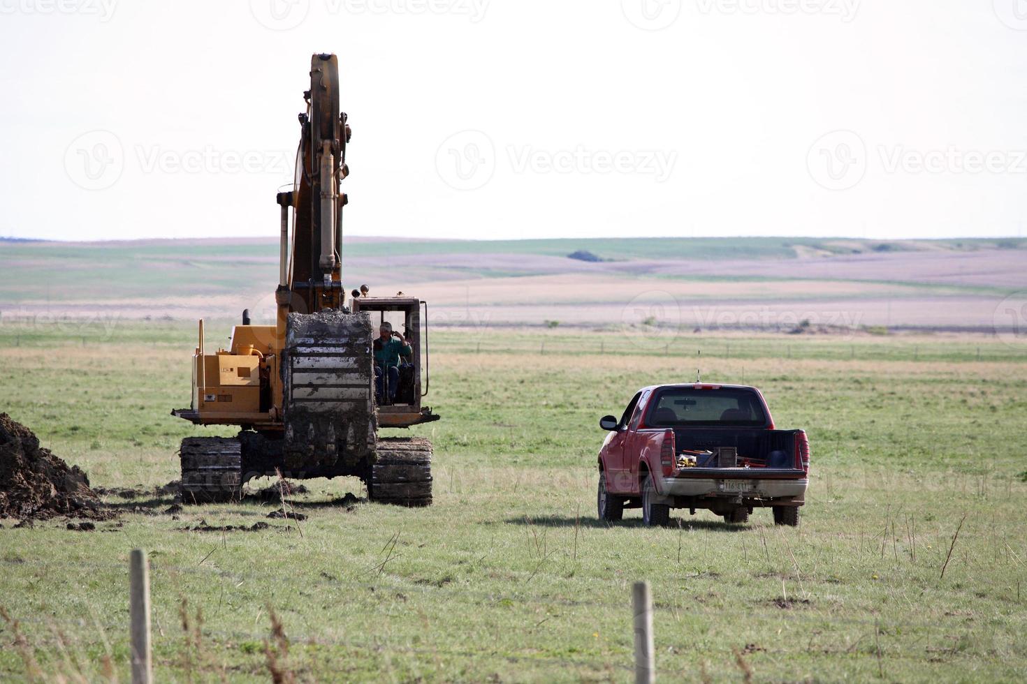 Raupenhacke und LKW in einem Feld in Saskatchewan foto