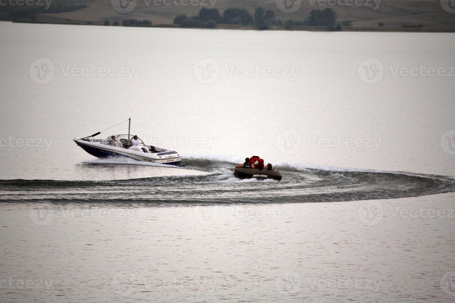 Motorboot, das ein Floß auf dem See Diefenbaker schleppt foto