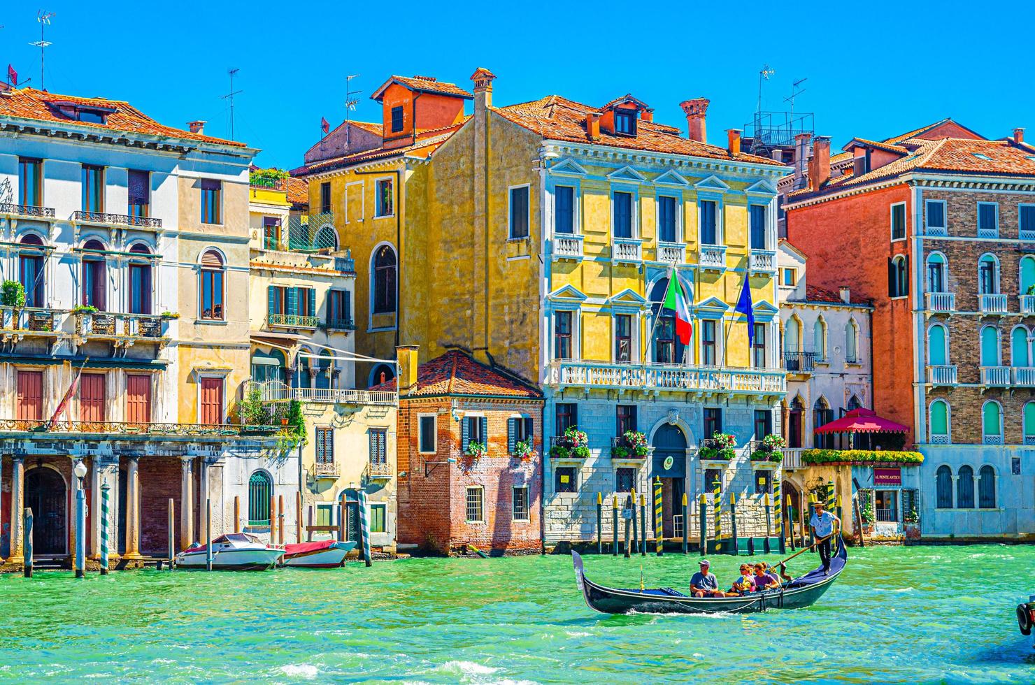 gondoliere und touristen auf der gondel traditionelles boot segeln auf dem wasser des canal grande in venedig foto