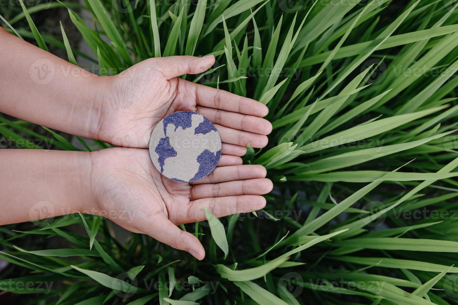 rette die erde für ein nachhaltiges lebensstilkonzept, schütze den planeten erde für nachhaltige ressourcen. menschliche hände, die globussymbol auf grasblatthintergrund halten. tag der erde und nachhaltigkeitsentwicklung. foto