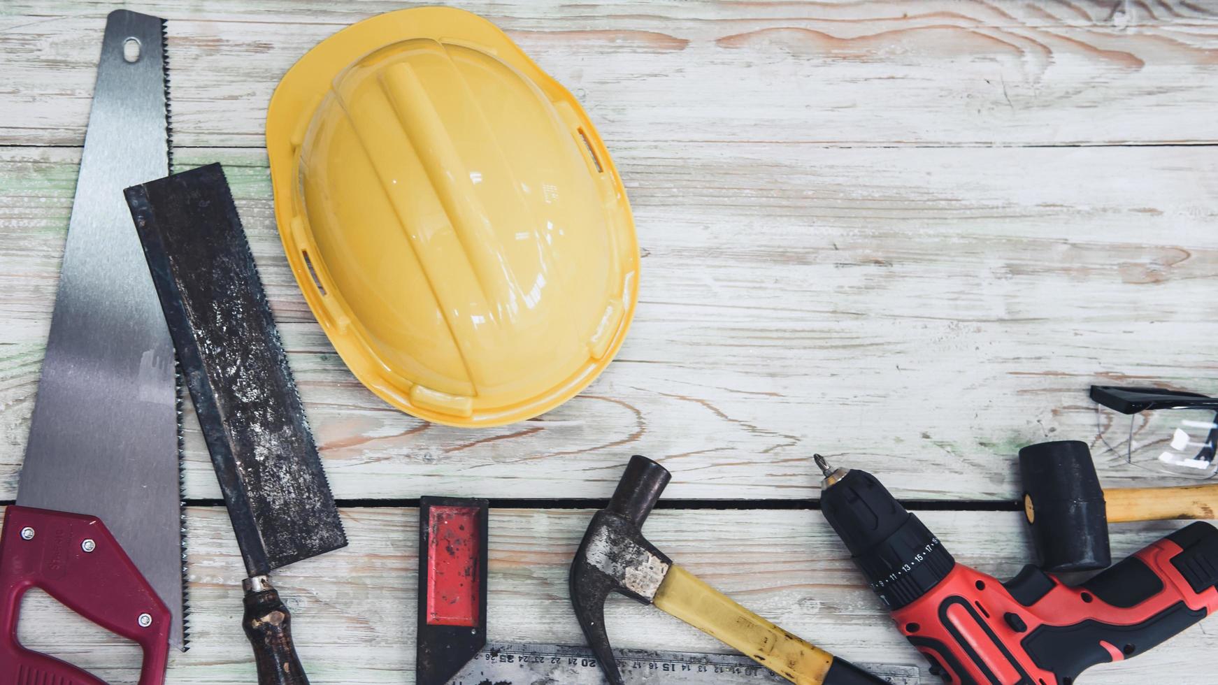 hauswartung und heimwerkerarbeiten, sicherheitsausrüstungen und handwerkzeuge für heimwerkerarbeiten aus holz auf tischholzhintergrund. Tischlerwerkzeuge für Gebäudereparaturen und Holzhandwerk foto