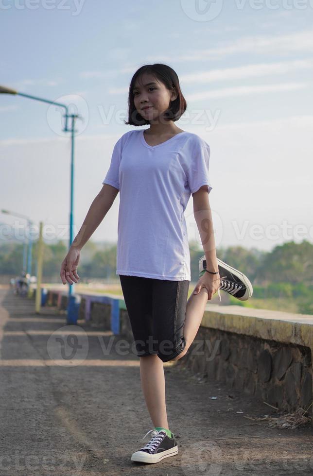 junge asiatische frau hat sich vor dem joggen und laufen morgens gestreckt foto