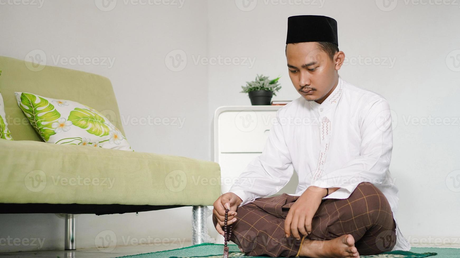asiatischer muslimischer Mann, der Dhikr macht foto