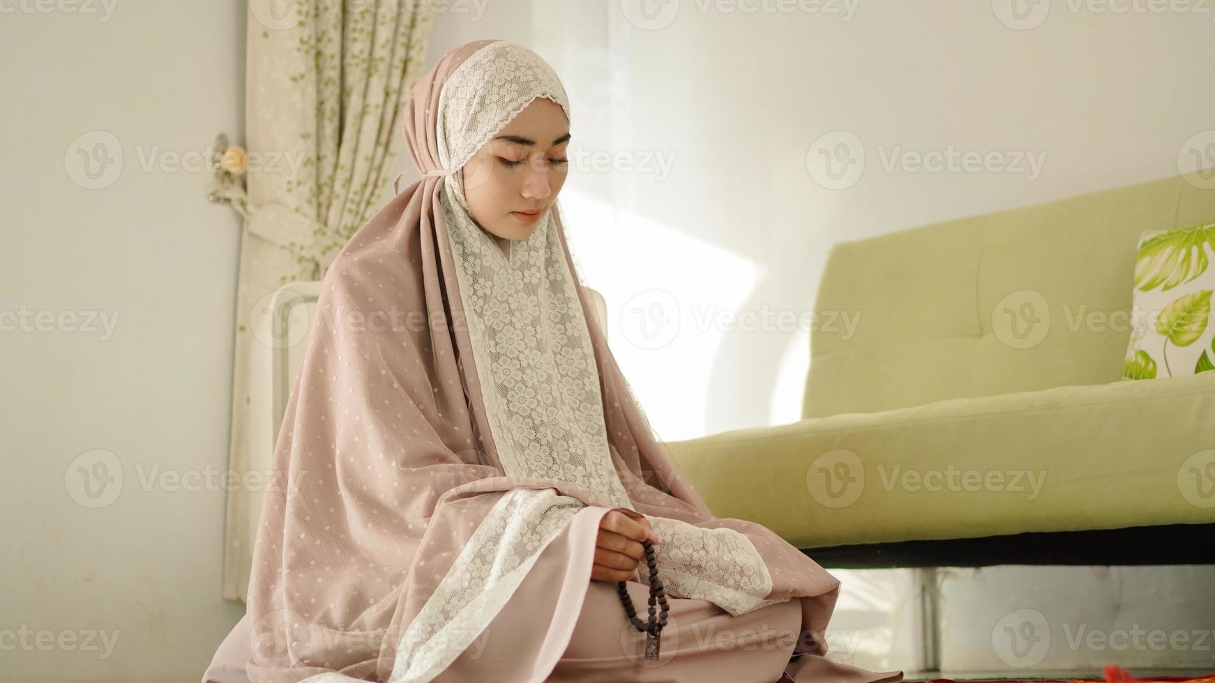 muslimische frau, die gebetsperlen für dhikr hält, nachdem sie salat durchgeführt hat foto