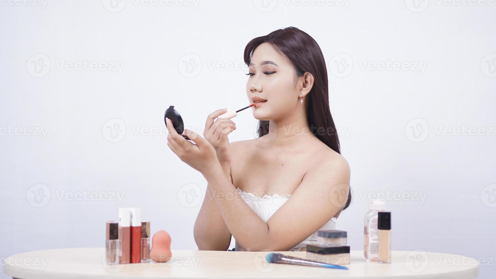 schöne asiatische Make-up-Spiegel für die Lippen isoliert auf weißem Hintergrund foto