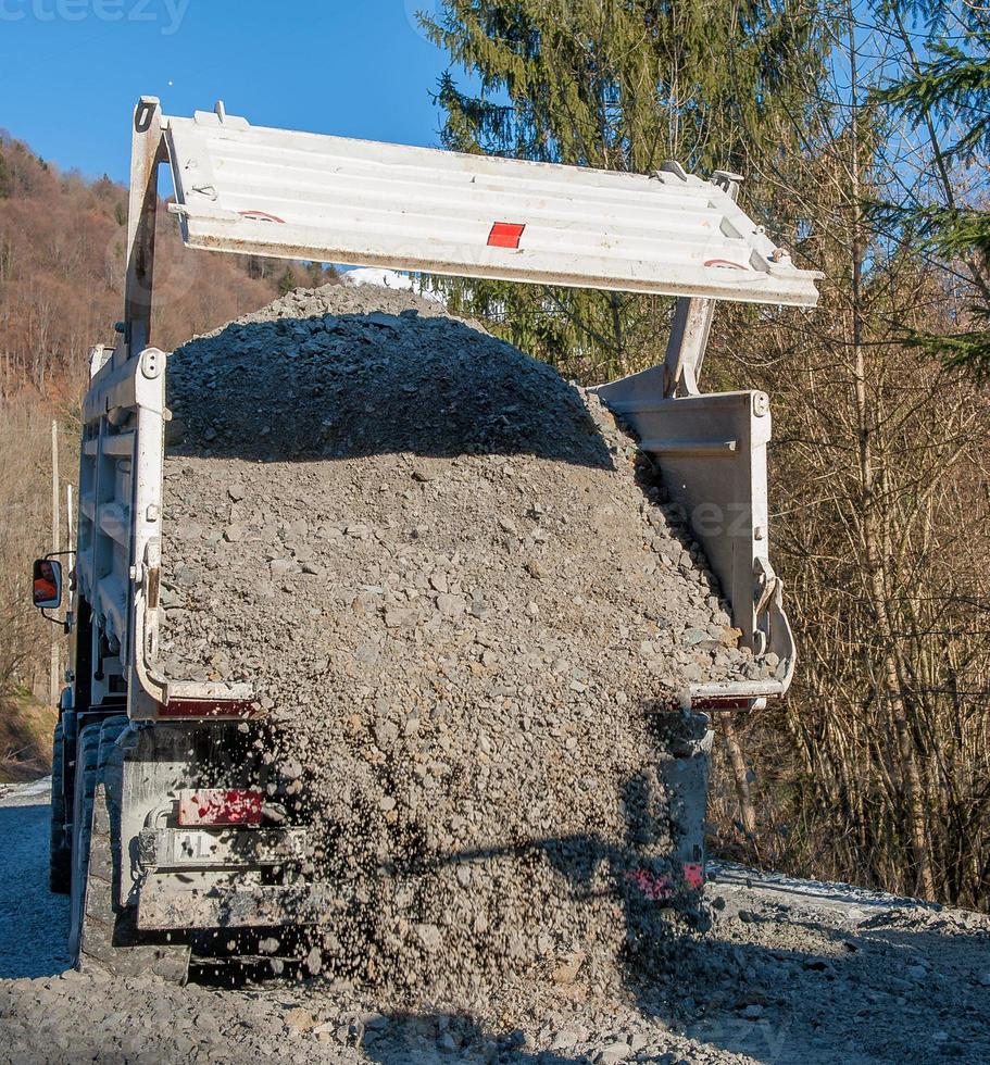 Überrollen von Schotter von Lastwagen foto