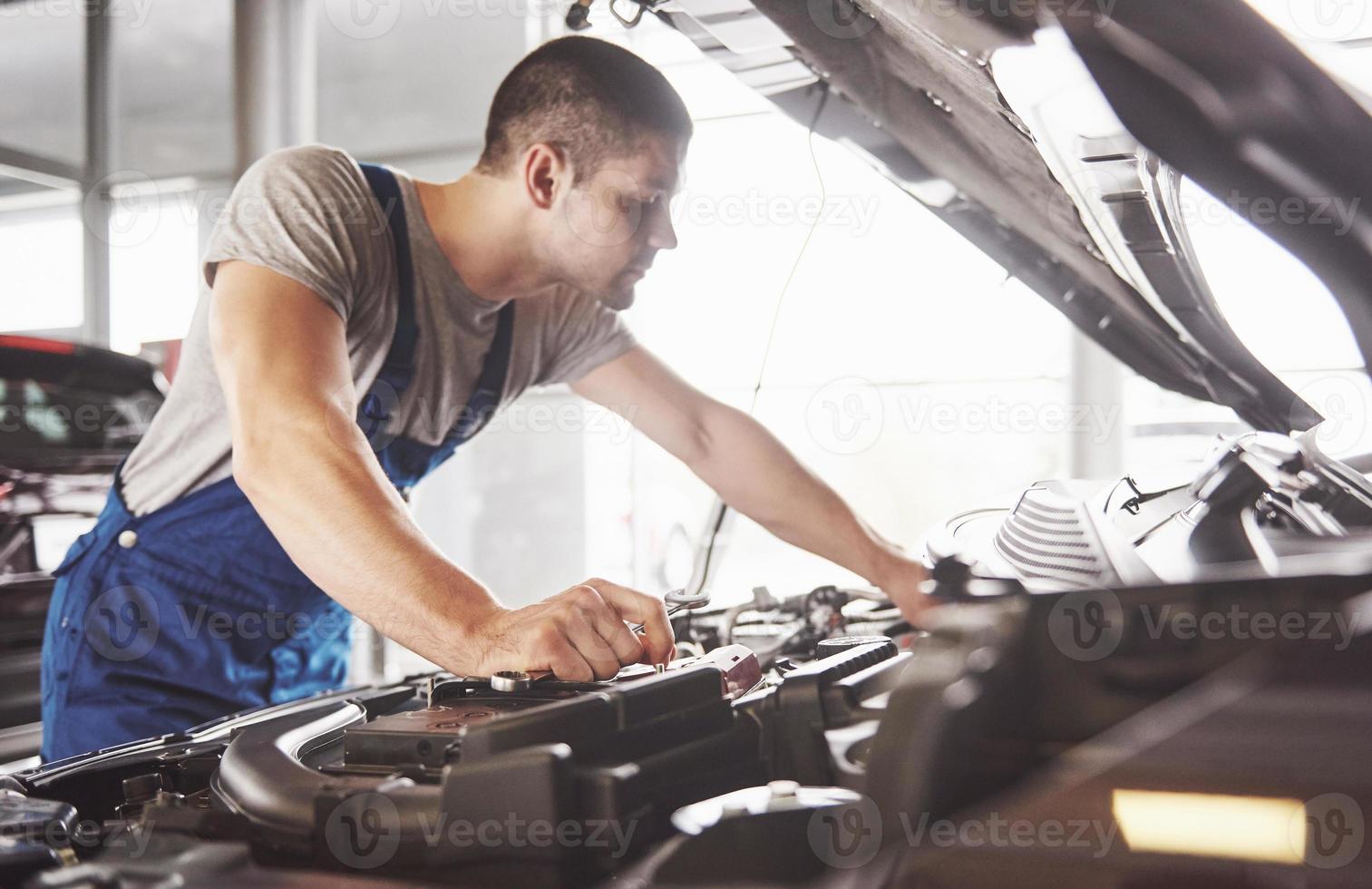 Automechaniker arbeitet in der Garage. Reparaturdienst foto
