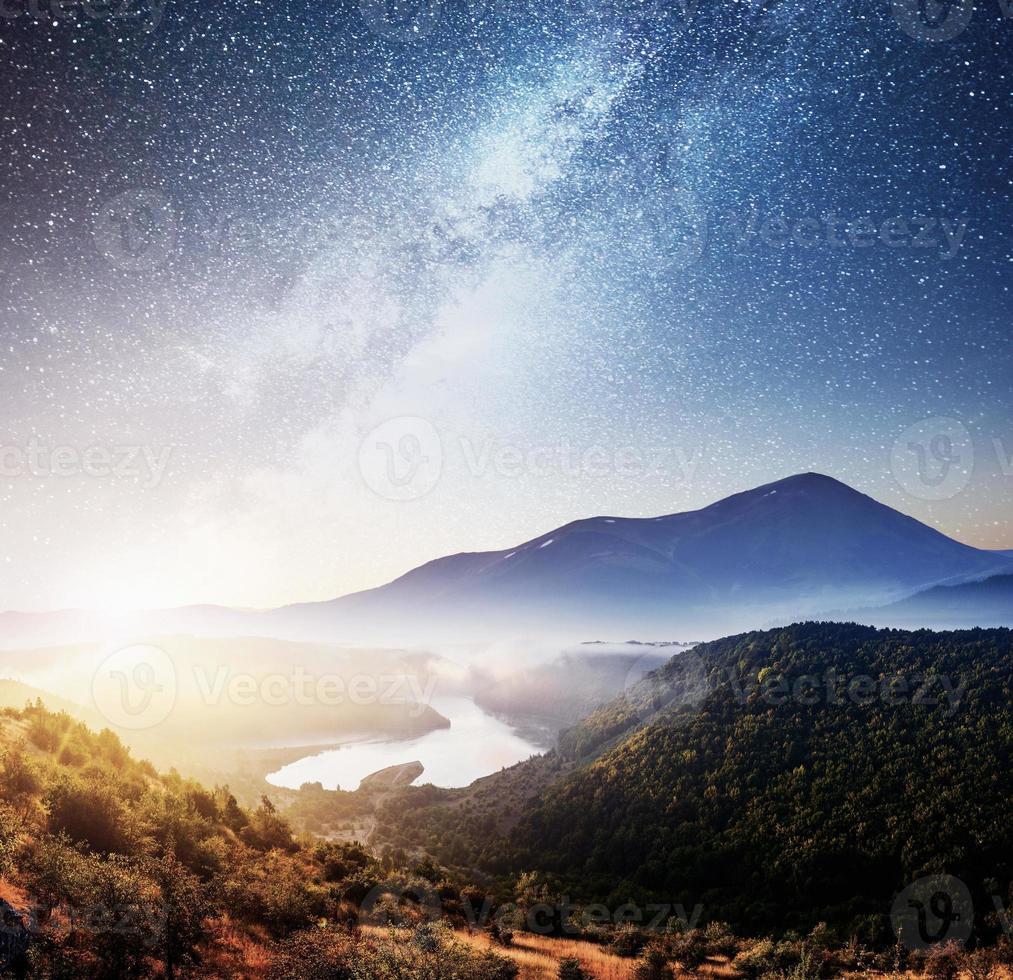 schöne Berglandschaft mit Blick auf den Fluss, lebendiger Nachthimmel foto