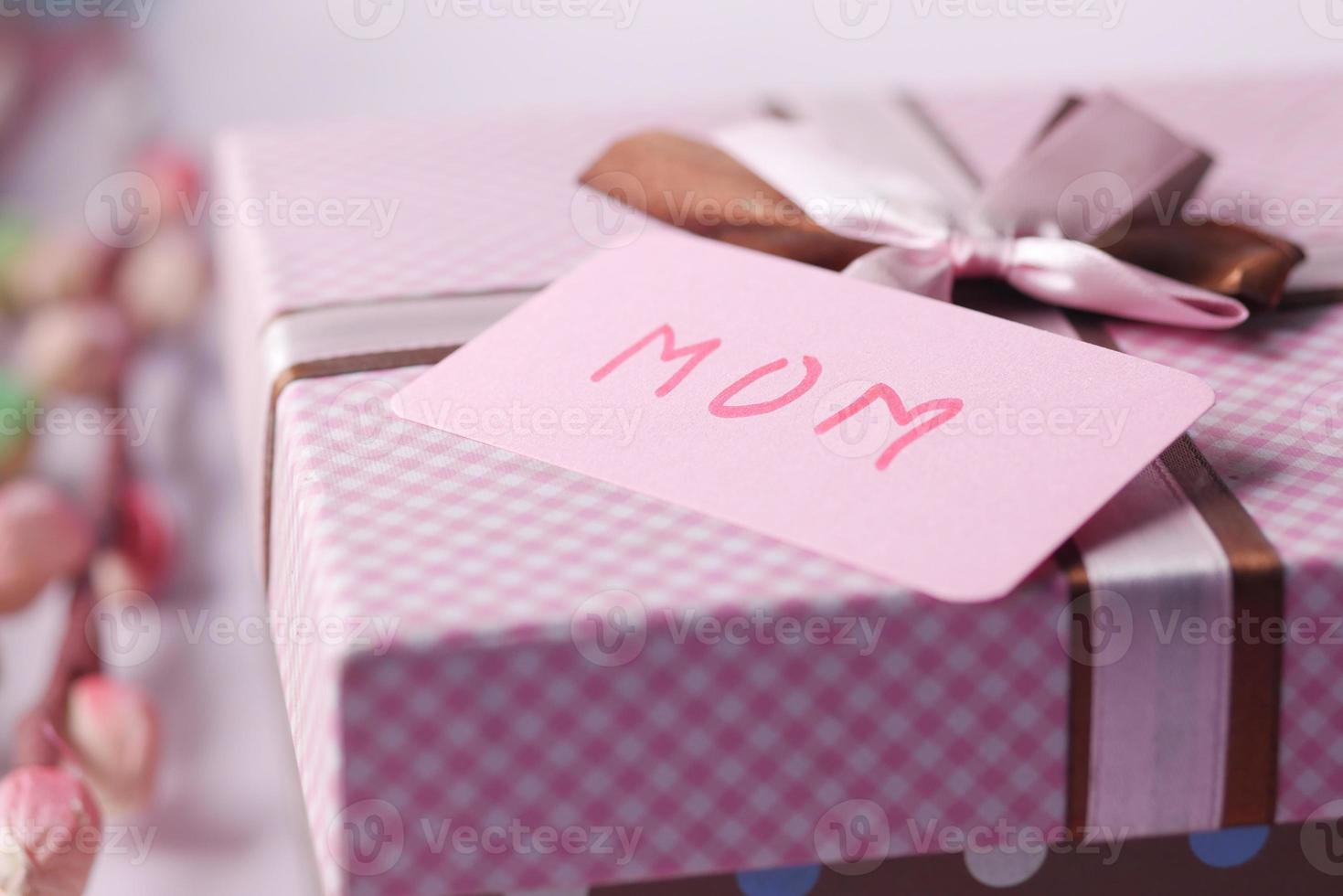 f Muttertagsgeschenk und Blume auf dem Tisch. foto