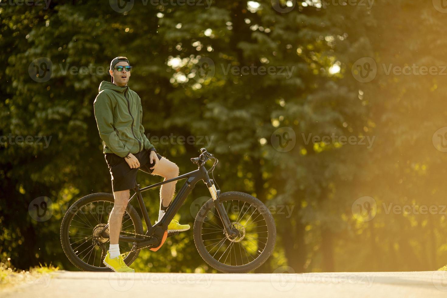 junger mann, der ebike in der natur fährt foto