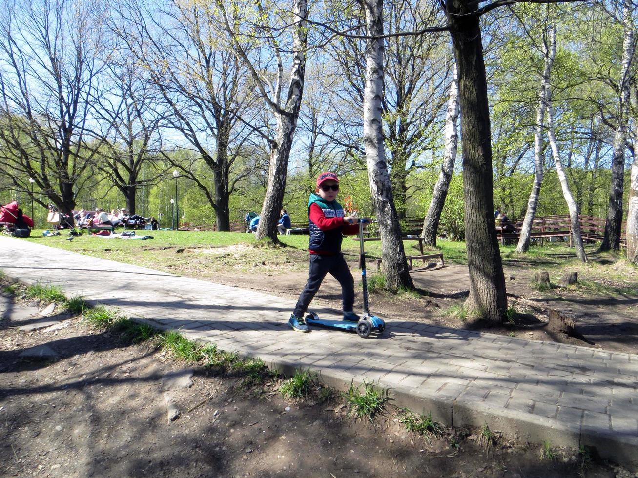 Moskau, Russland. 14. Mai 2017. Troparevo-Park. ein Junge fährt einen Roller foto