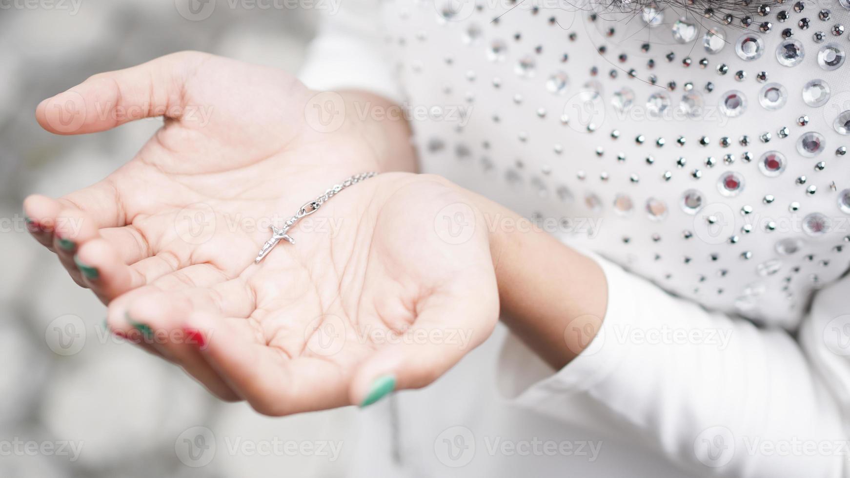 frauenhand mit einem kreuz und einer bibel foto