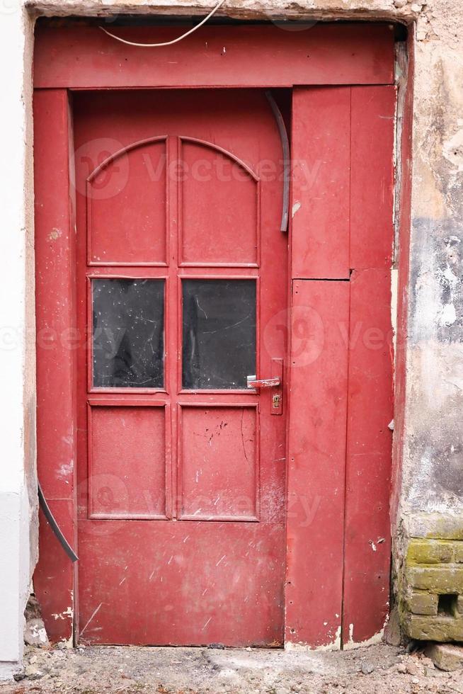 rote holztür mit glas in gealterter betongebäudewand foto