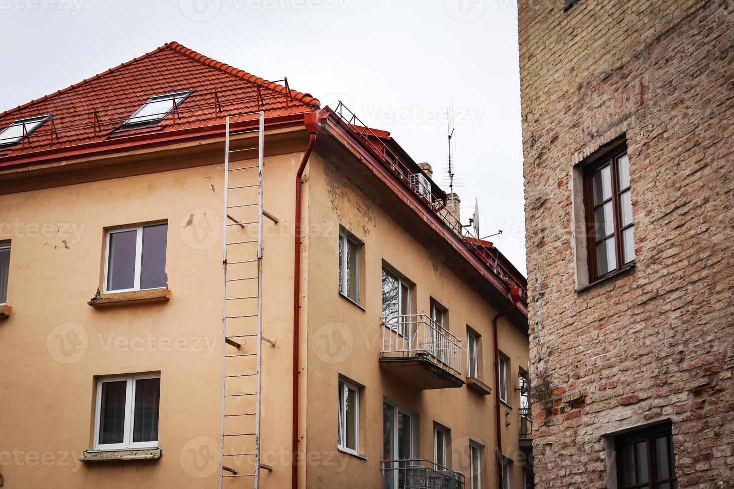 Alte und renovierte Gebäude stehen nahe beieinander mit weißem Himmel über dem Dach foto