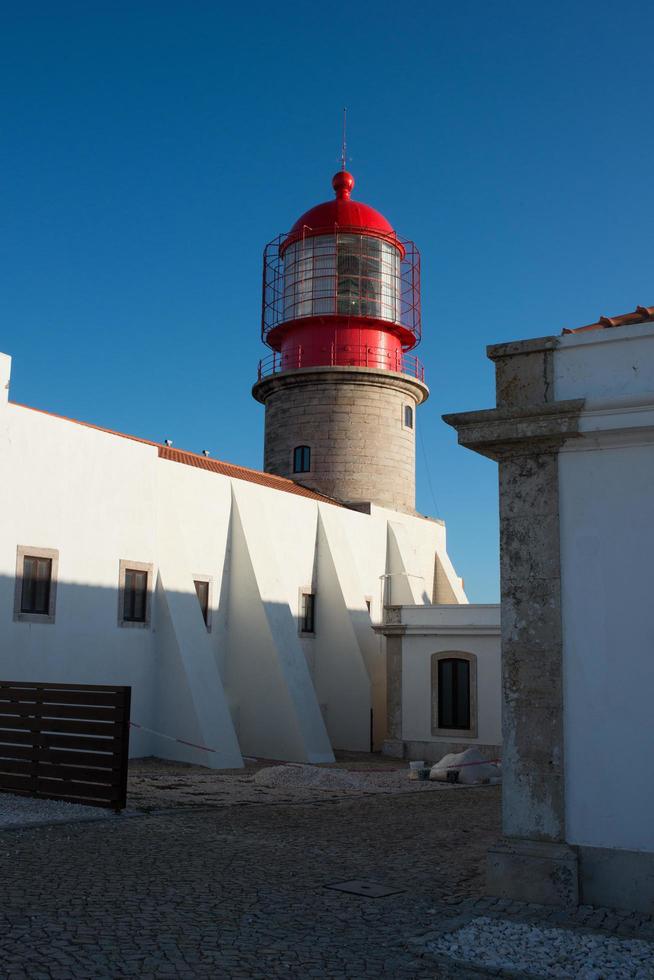 weißes gebäude neben dem leuchtturm am cape st vincent, algarve, portugal foto