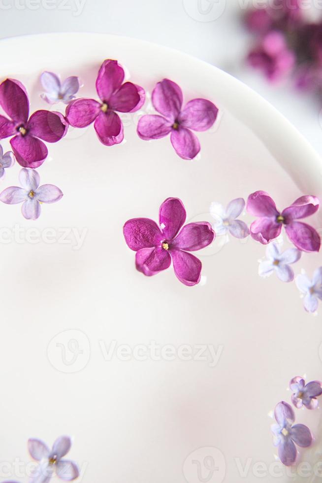 fünfzackige Fliederblüte inmitten von Fliederblüten in einer Tasse mit Wasser. Platz für Text schaffen. Fliederzweig mit einer Blume mit 5 Blütenblättern. foto