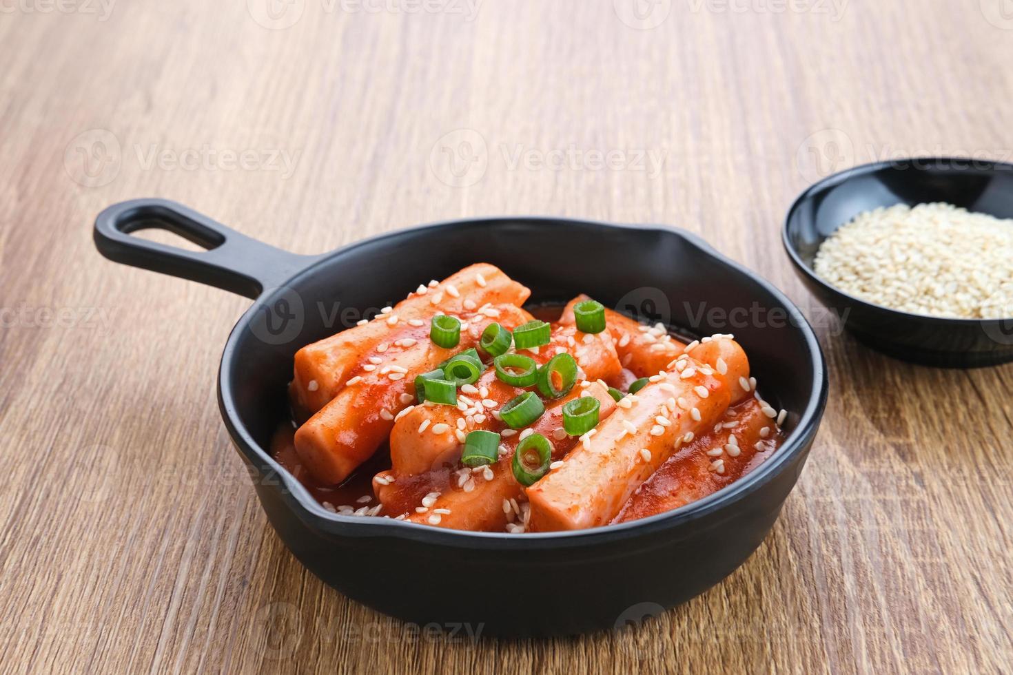 tteokbokki oder topokki, gebratener reiskuchenstock, beliebtes koreanisches straßenessen mit würziger gochujang-sauce und sesamsamen. foto