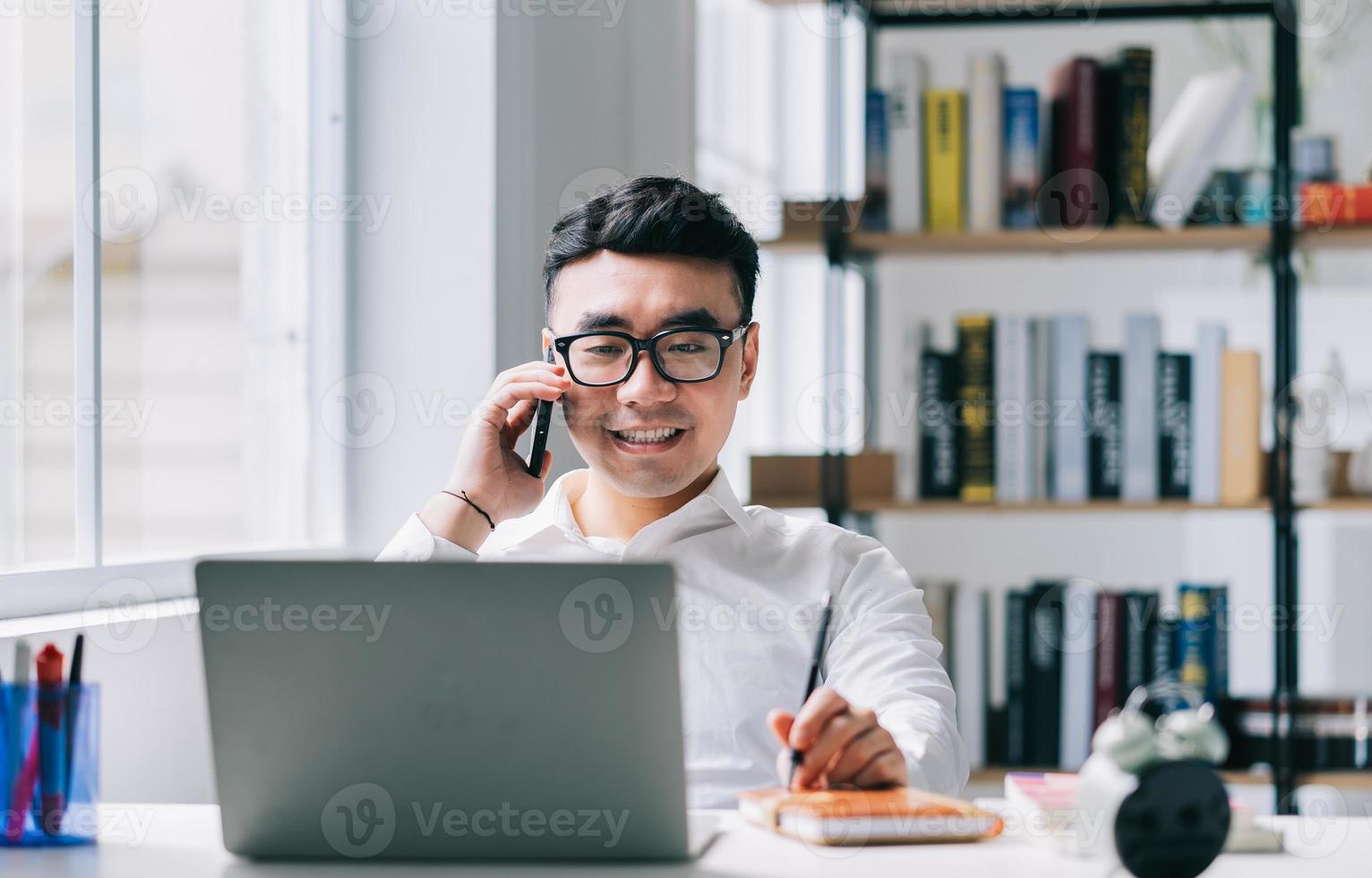 junger asiatischer geschäftsmann, der im büro arbeitet foto