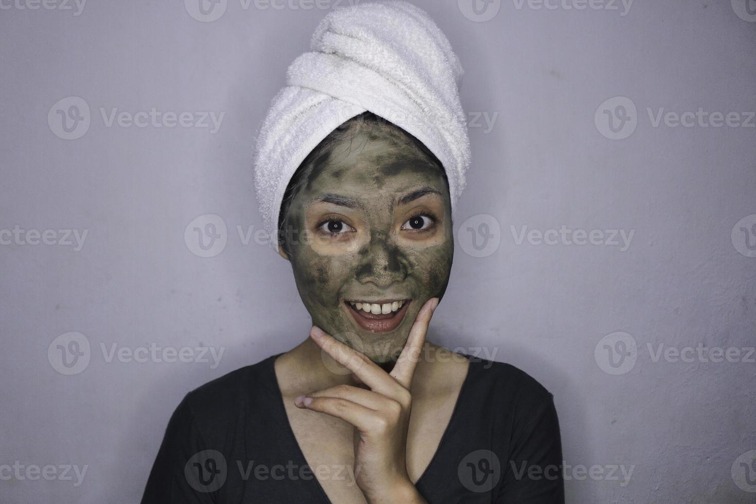 lächeln asiatische frauen lächeln, wenn sie eine schönheitsgesichtsmaske verwenden foto