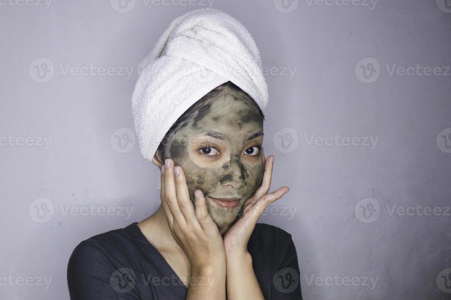 lächeln asiatische frauen lächeln, wenn sie eine schönheitsgesichtsmaske verwenden foto