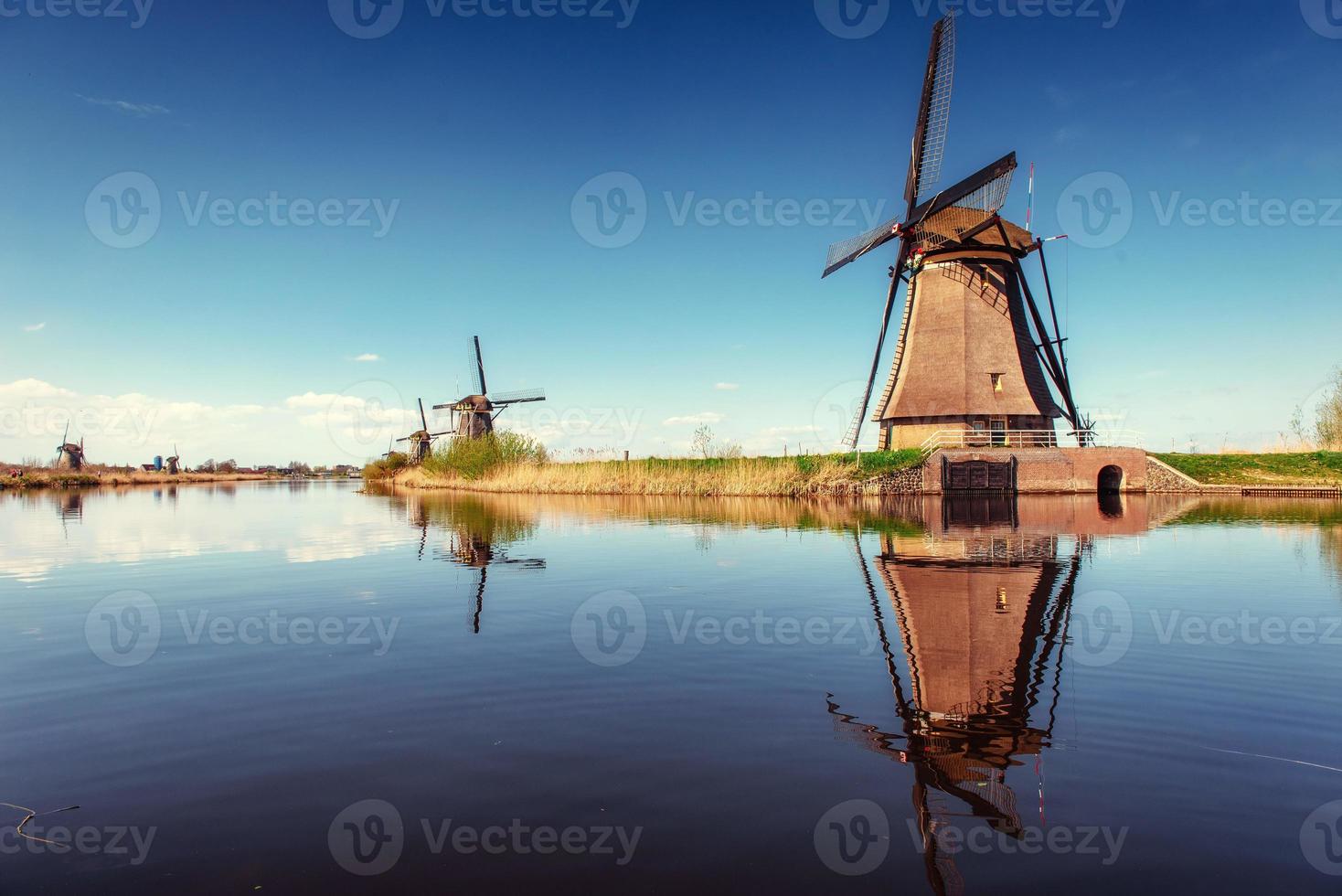 bunter frühlingstag mit traditionellem holländischem windmühlenkanal in ro foto