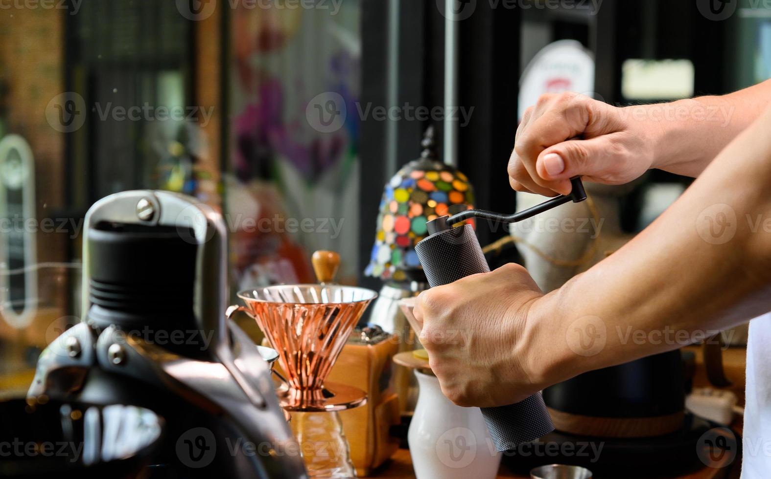 Barista mahlt Kaffeebohnen für Drip Brew foto