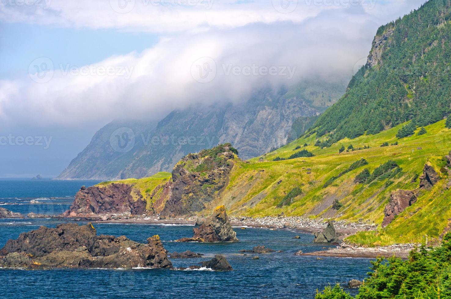 Wolken und Klippen entlang einer Ozeanküste foto