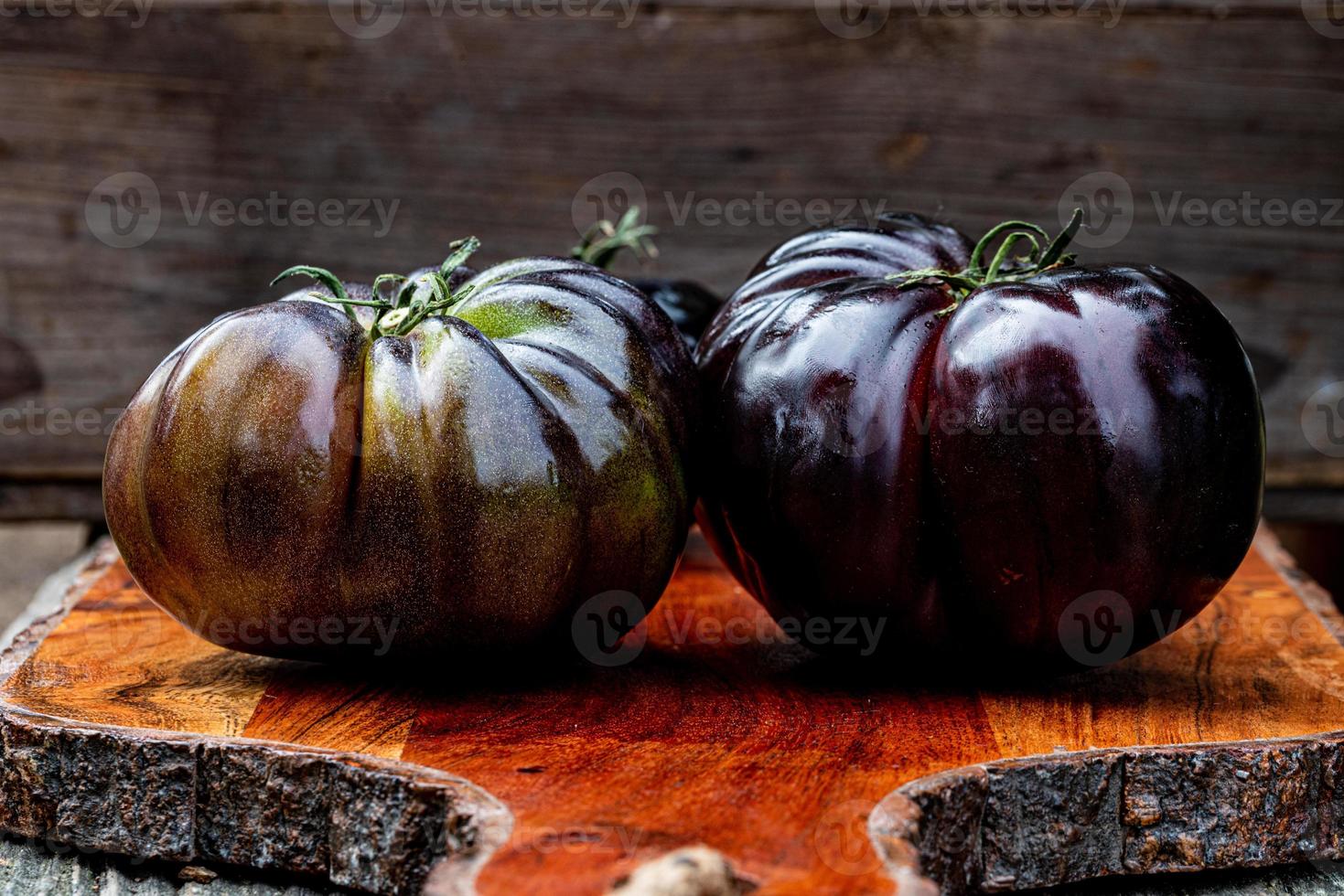 schwarze Urtomaten auf Schneidebrett foto