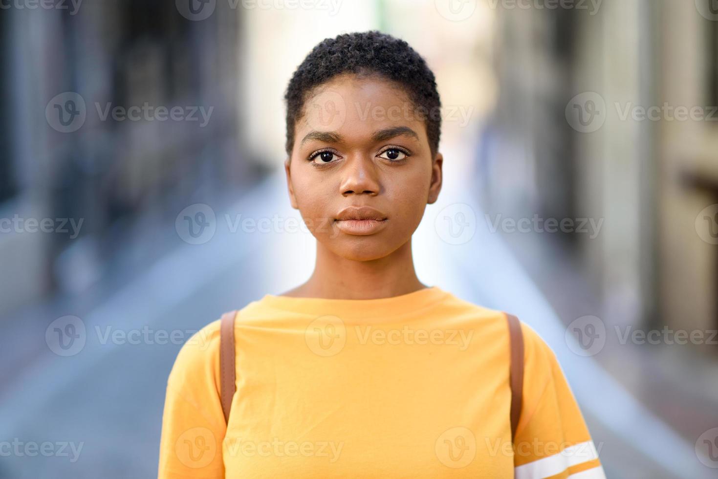 junge afrikanische frau, die lässige kleidung trägt und in die kamera schaut. foto