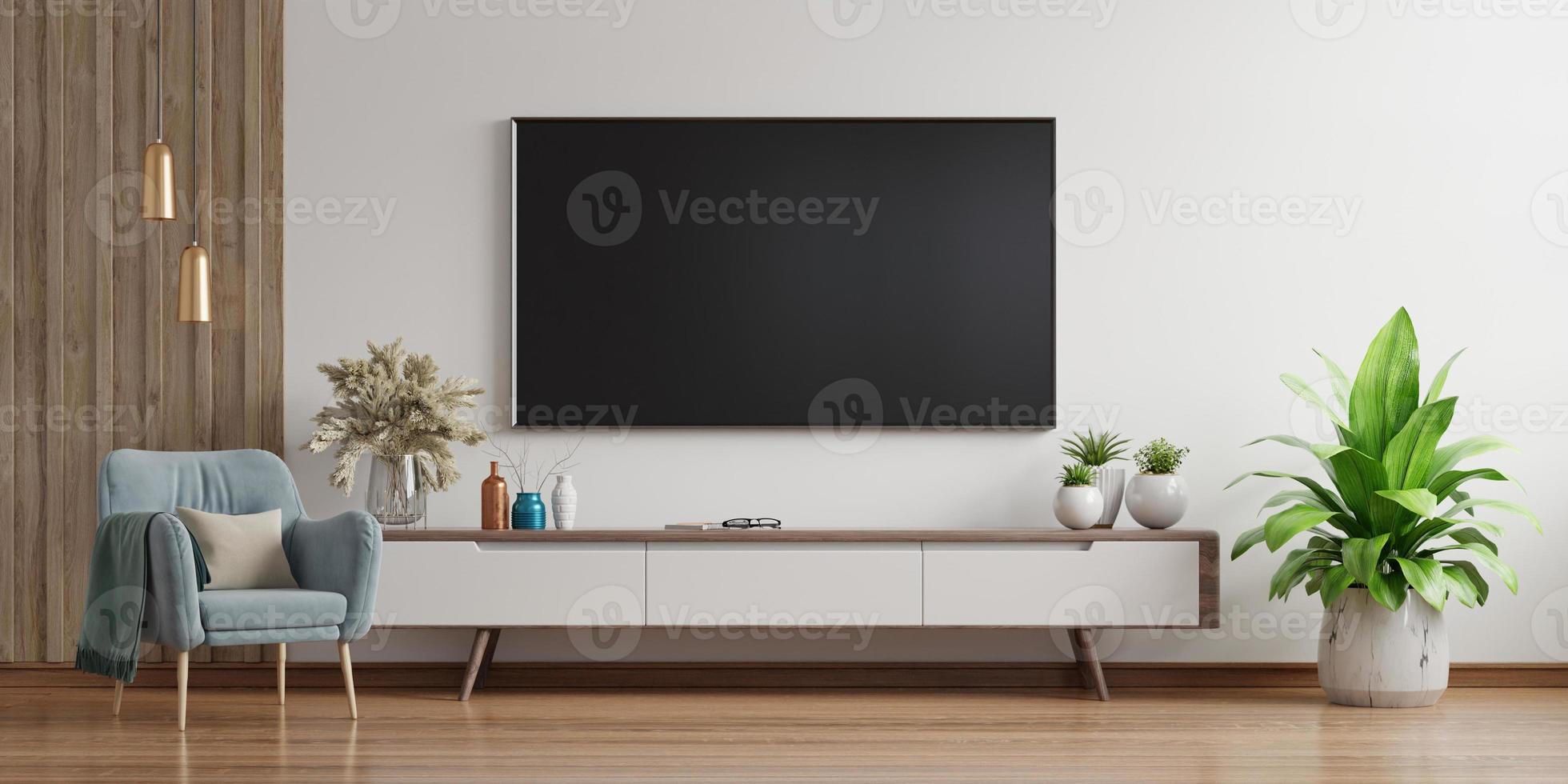smart tv an der weißen wand im wohnzimmer mit sessel, minimalistisches design. foto