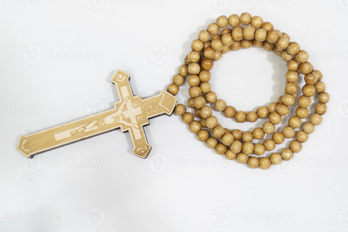 Rosenkranz mit Kreuz aus grauem Holz auf weißem Hintergrund, ausgewählter Fokus auf Christus, schmale Schärfentiefe. foto