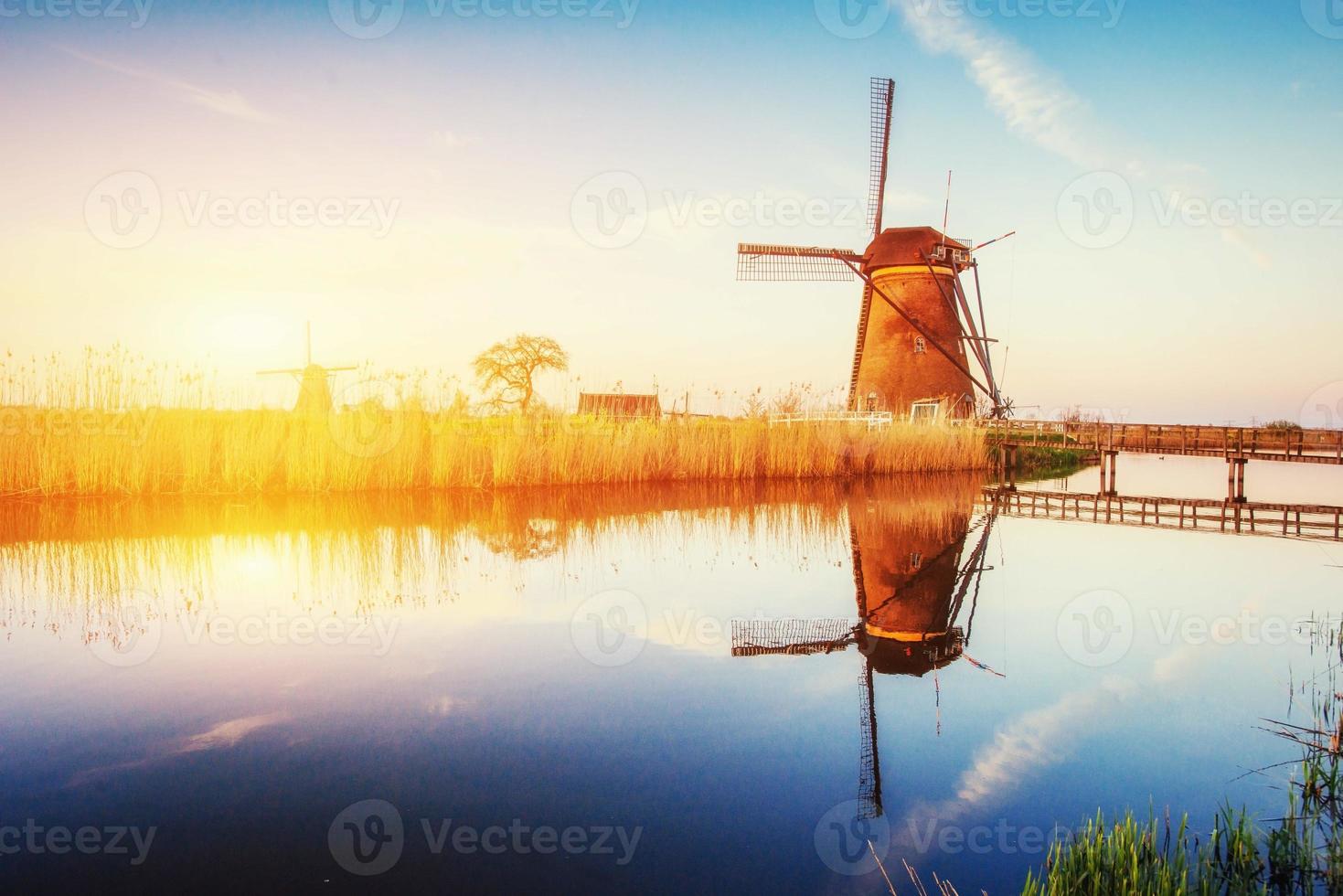 Holländische Mühle bei Sonnenuntergang vom Kanal in Rotterdam. Holland foto