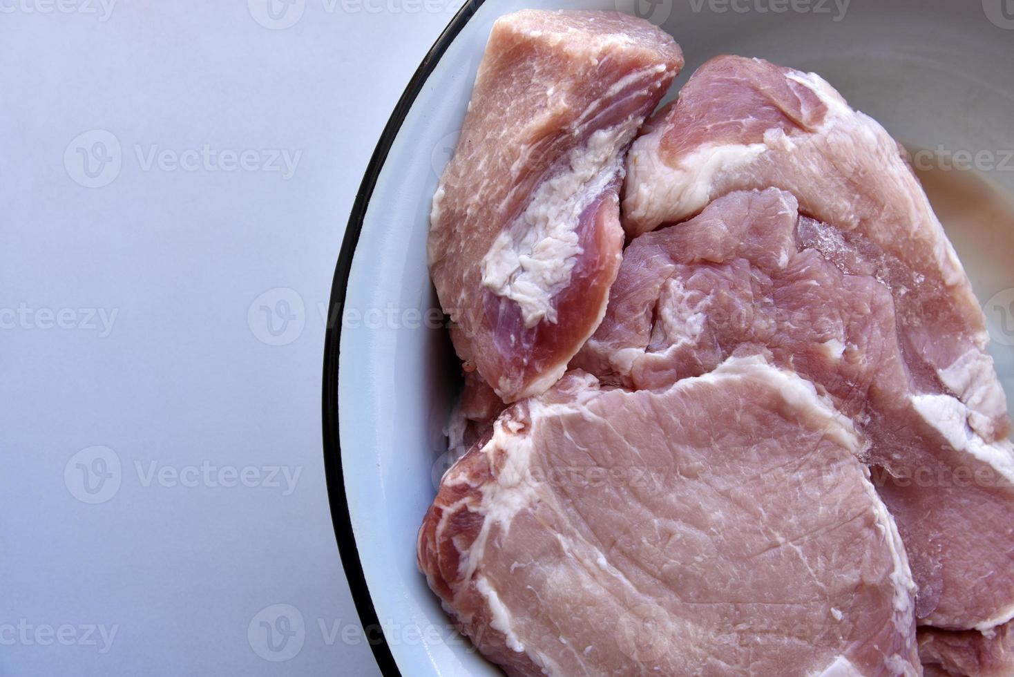 Stücke von frischem Schweinefleisch in einem Topf foto