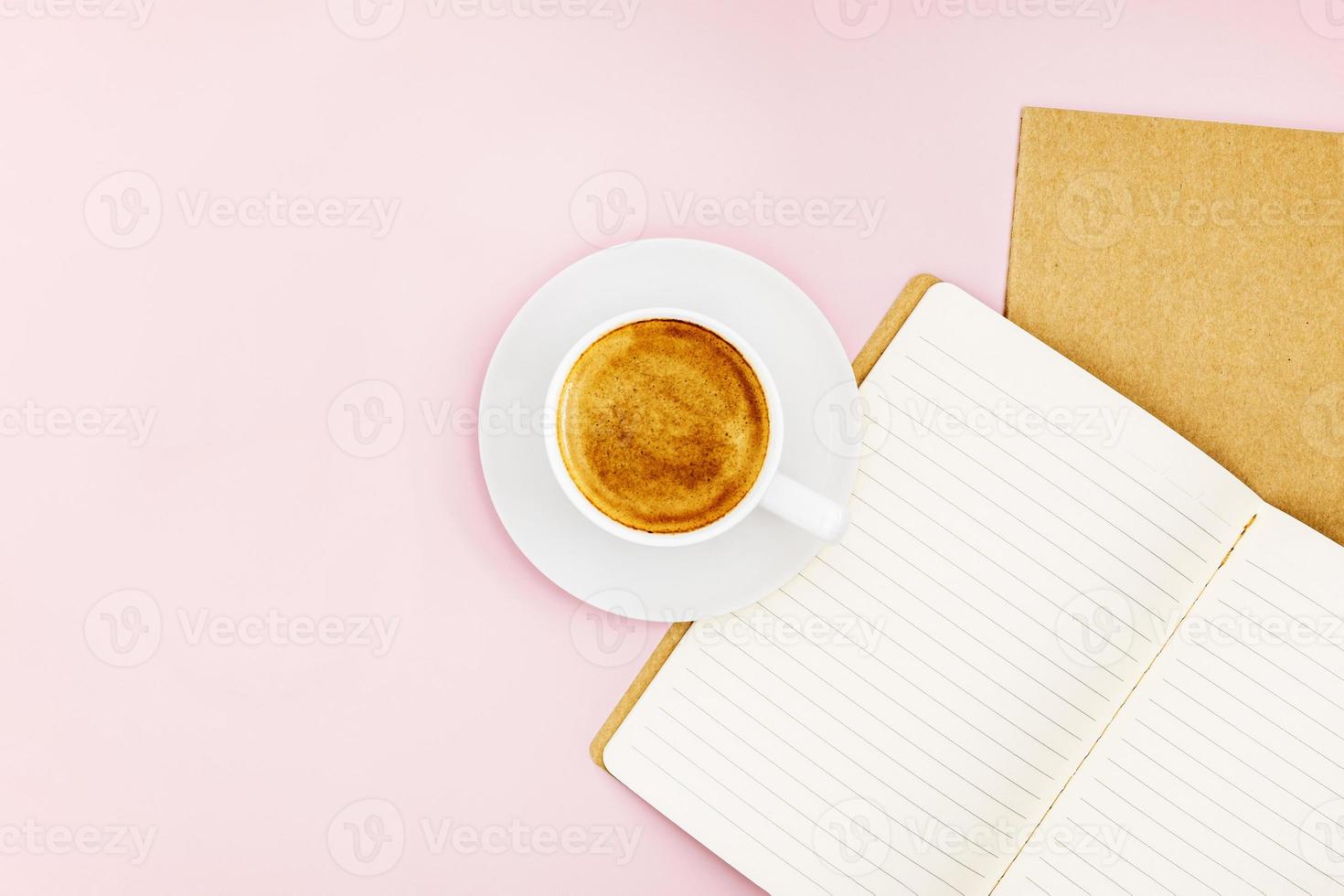 zwei Notizbücher zum Schreiben und eine weiße Porzellantasse mit Kaffee foto