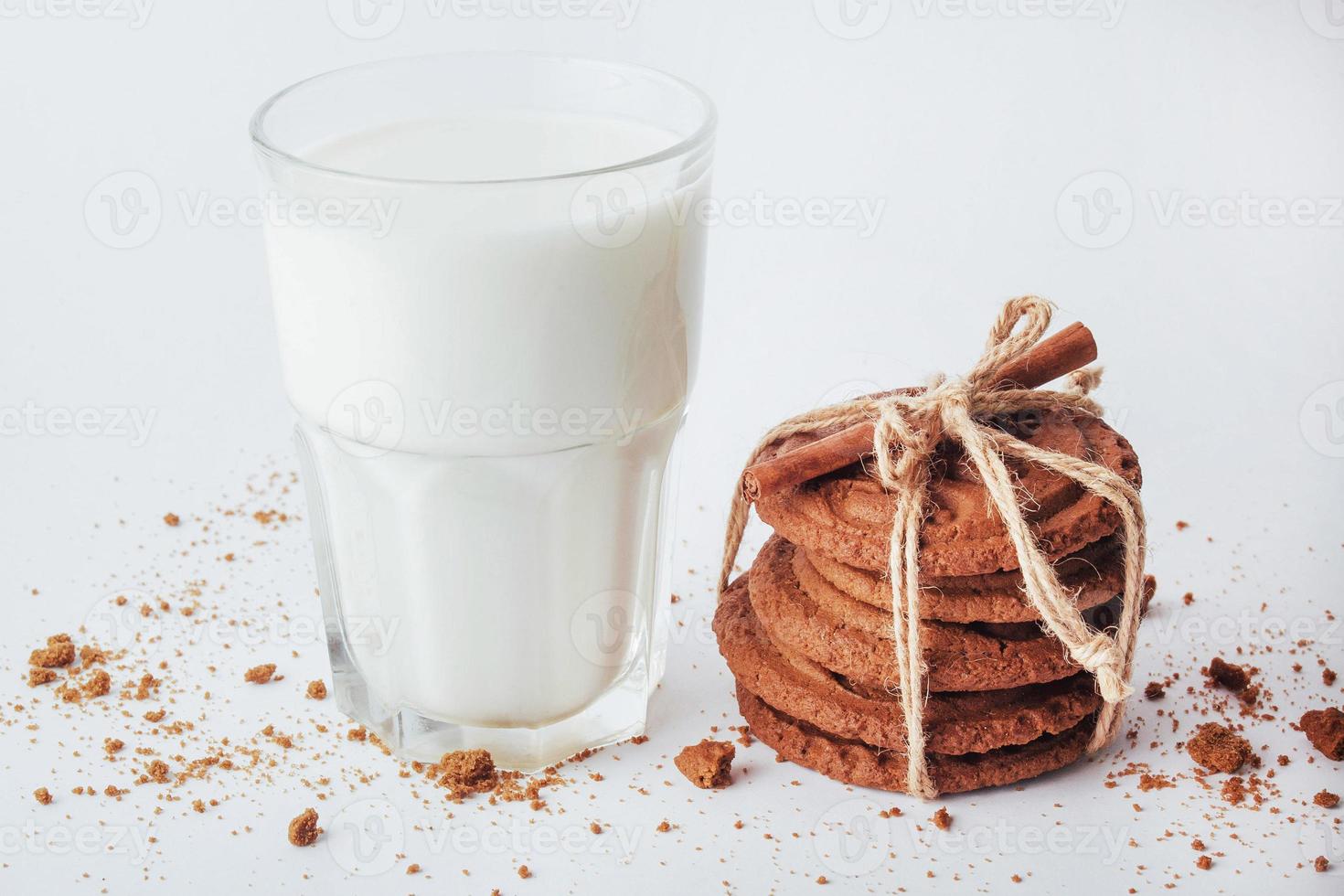 transparentes Glas Milch und Kekse auf weißem Hintergrund foto
